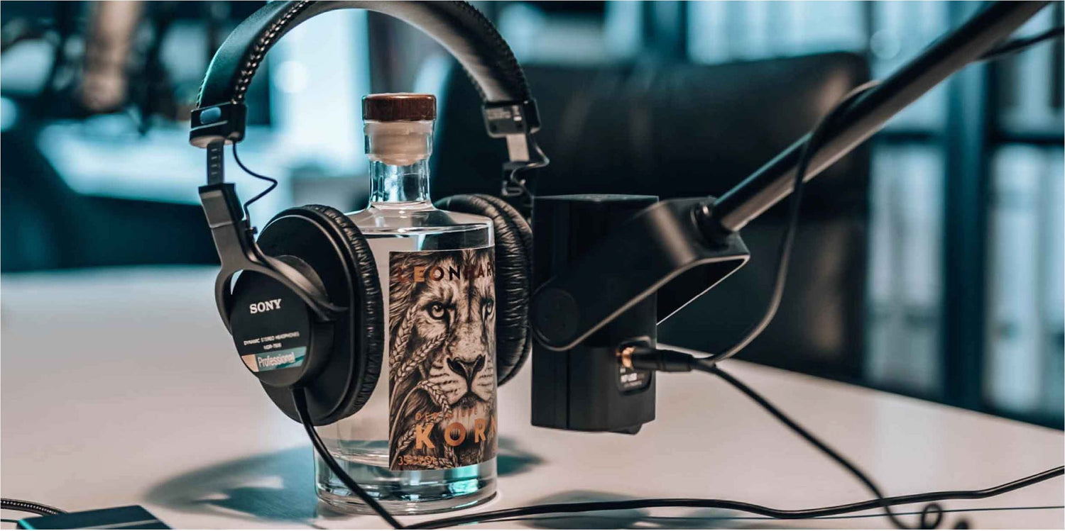 Leonhardt Korn Podcast Flasche mit Mikrofon und Kopfhörern